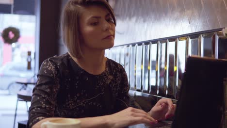 Woman-working-on-her-laptop-and-enjoying-her-coffee