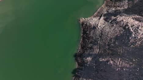 Aerial-view-descending-to-Sau-reservoir-blue-green-river-Ter-shoreline-looking-down-mountain-valley