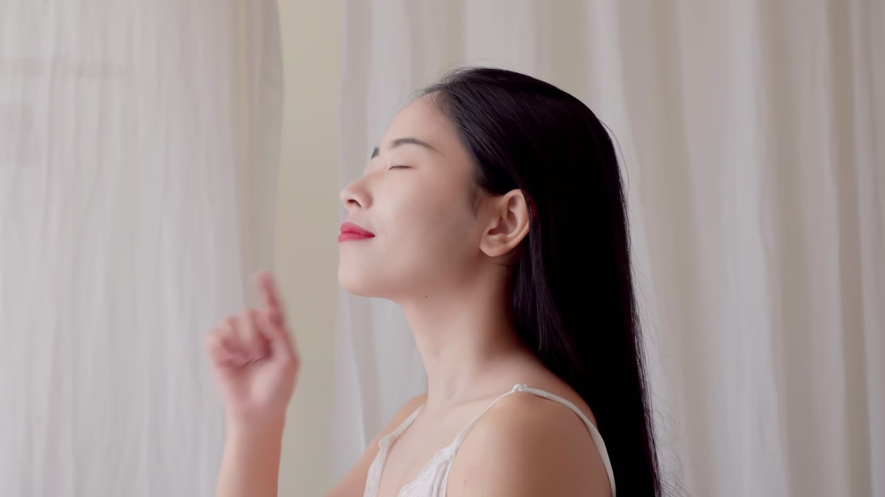 피자마를 입은 아름다운 여성의 피부 관리 피부 관리 얼굴이 건강 관리 제품을 적용하여 깨어나며, 웰니스 신체 관리 및 미용을 위해  바탕에 고립됩니다.