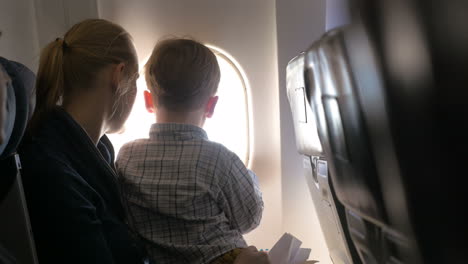 Madre-E-Hijo-Mirando-Iluminador-En-Avión.