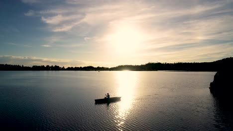 beautiful colorado sunrise on a lake with a silhouette of a canoe against the rising sun