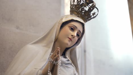 Close-up-of-white-dressed-Virgin-Mary-statue-in-church,-faith-and-devotion