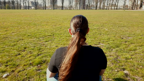 Cerrar-Una-Toma-Detrás-De-La-Mujer-Adulta-Con-Una-Camiseta-Negra-Está-Cagando-Y-Relajándose-En-El-Parque-Tranquilo