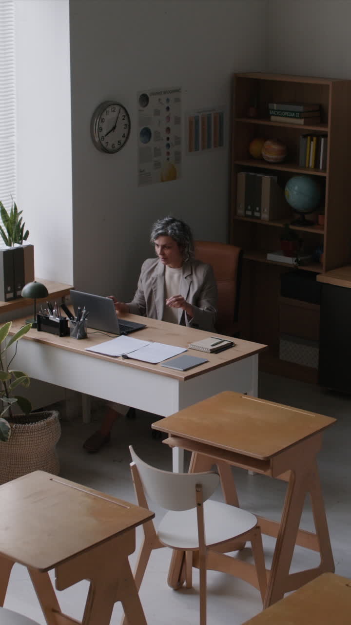 Teacher working at a desk in a modern classroom
