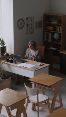 Teacher working at a desk in a modern classroom