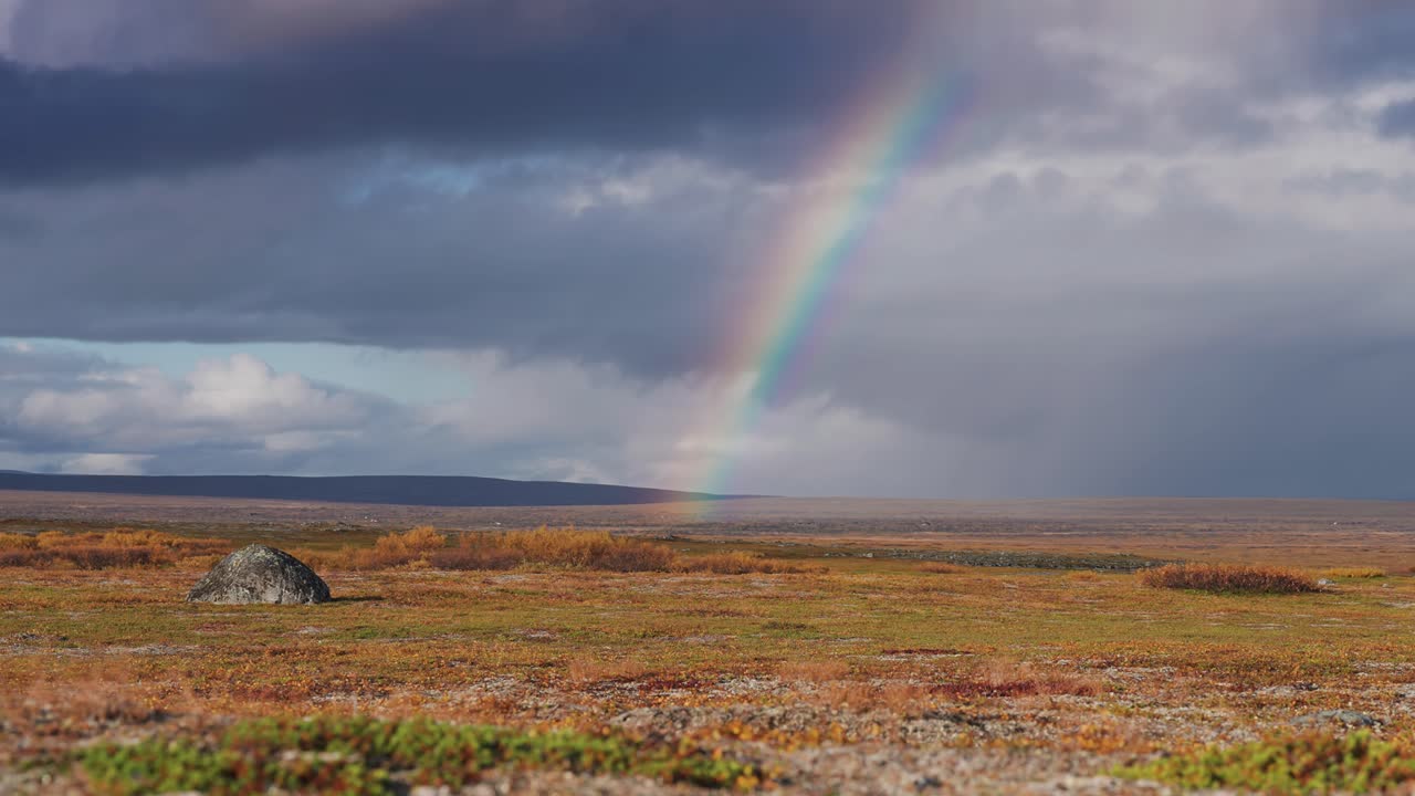 un arco iris colorido sobre el desolado paisaje nórdico