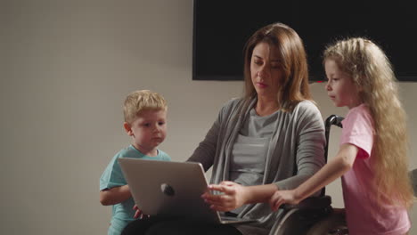 Curious-preschooler-and-toddler-bother-mom-working-on-laptop