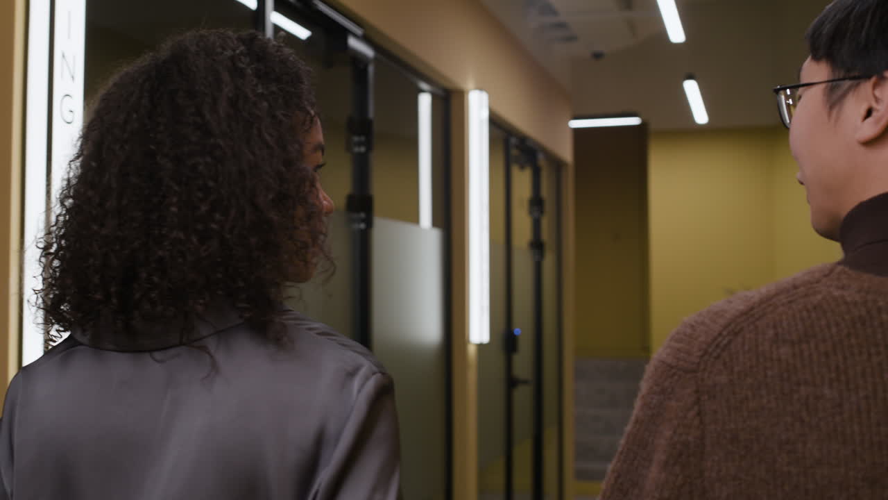 People conversing in an office hallway