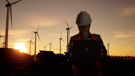 engineer working at a wind and solar farm at sunset