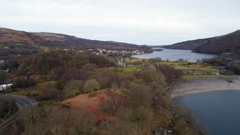 Eine-Luftaufnahme-Der-Burg-Dolbadarn-An-Einem-Bewölkten-Tag,-Die-Auf-Die-Burg-Zufliegt,-Mit-Der-Stadt-Llanberis-Im-Hintergrund,-Gwynedd,-Wales,-Großbritannien