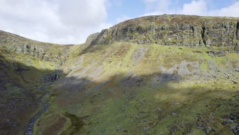 Aerial-dark-cloud-moves-down-the-valley-to-reveal-the-Mahon-Falls-Comeragh-Mountains-Waterford-Ireland-on-a-early-spring-day-nature-at-its-best