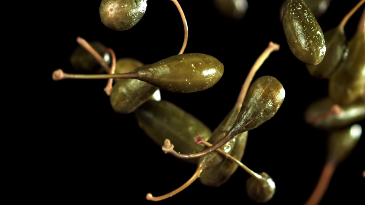 Capperi verdi che cadono in super slow motion