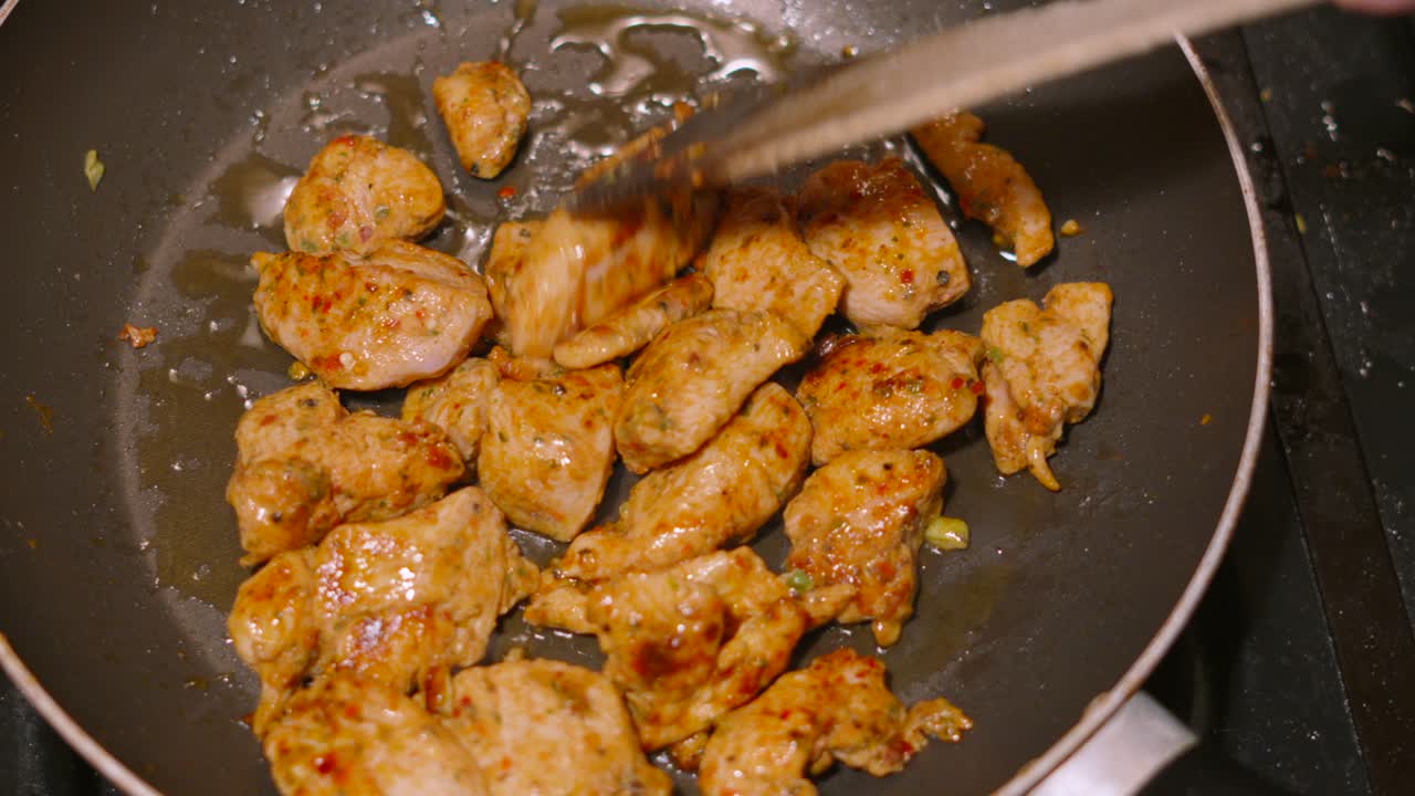 Rotating Overview of Chef Cooking Pieces of Chicken Marinated in Chinese Spices in Hot Pan with Oil Bubbling and Chunks Being Turned Rapidly. High Protein Low Fat Dinner Recipe 4K.