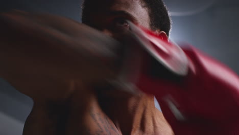 nahaufnahme eines boxers, der den ring betritt und sich vor beginn des boxkampfes mit niedriger beleuchtung aufwärmt