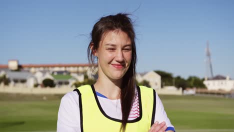 female soccer player standing with arms crossed on soccer field. 4k