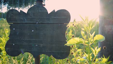 wooden signboard stands in field