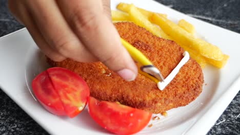 delicious fried chicken cutlet with fries and tomatoes