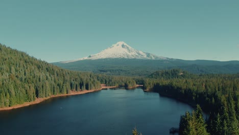 montaña nevada aérea de 4k con lago en primer plano drone dolly out