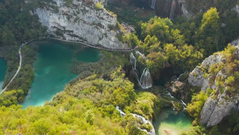 incredible aerial view of bright turquoise lakes and connected with waterfalls between rocky cliffs and dense forest