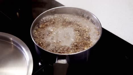 a pot of green lentils is about to boil over on a electric stove