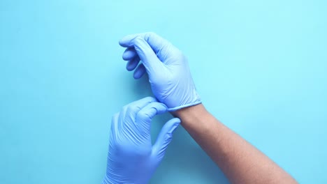 putting on blue medical gloves