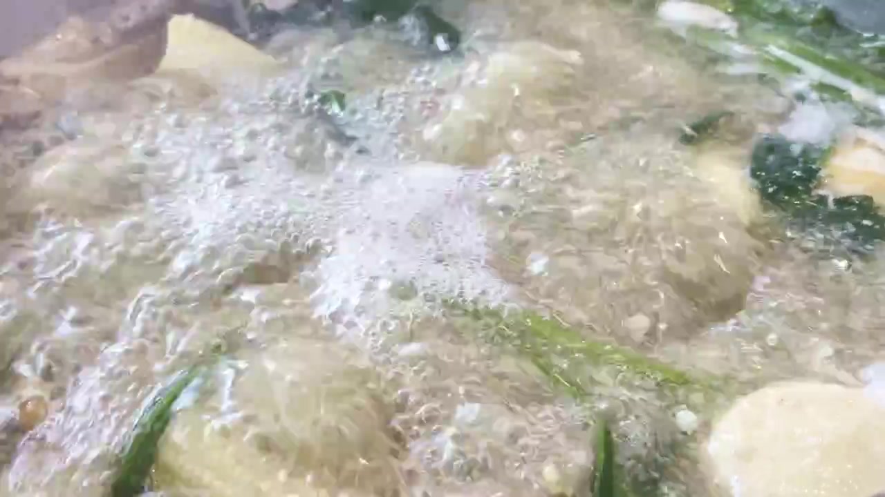 Gros plan sur un hot pot sukiyaki de style thaïlandais et chinois mijotant avec de la viande, des fruits de mer, des légumes frais et un bouillon savoureux dans un cadre de repas convivial.