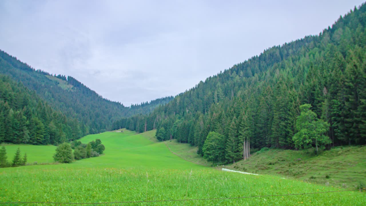 Pan right to left. Breathtaking mountain forest nature landscape. Cloudy spring day. Topla Valley, Slovenia