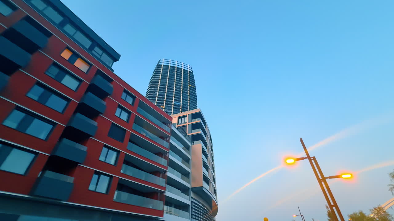 Contemporary buildings of diverse design in the urban landscape of Bratislava, Slovakia. Low angle view at the street light switched on at sunset