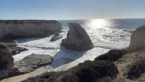 panning shot of a sunny day of strong waves at sharkfin cove along highway one on the pacific coast in northern california