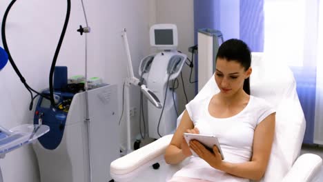 female patient using digital tablet in clinic