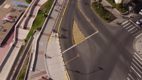 Luftaufnahmen-Von-Oben-Nach-Unten-Von-Radfahrern-Auf-Dem-Fahrrad-Auf-Der-Straße-Von-Mar-Del-Plata,-Argentinien---Schöner-Sonniger-Tag-Am-Abend-Auf-Gehweg-Neben-Sandstrand