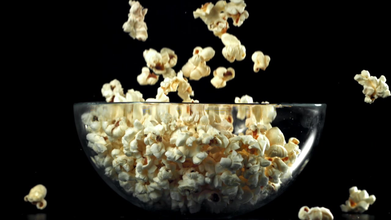 Popcorn al rallentatore che cade in una ciotola di vetro