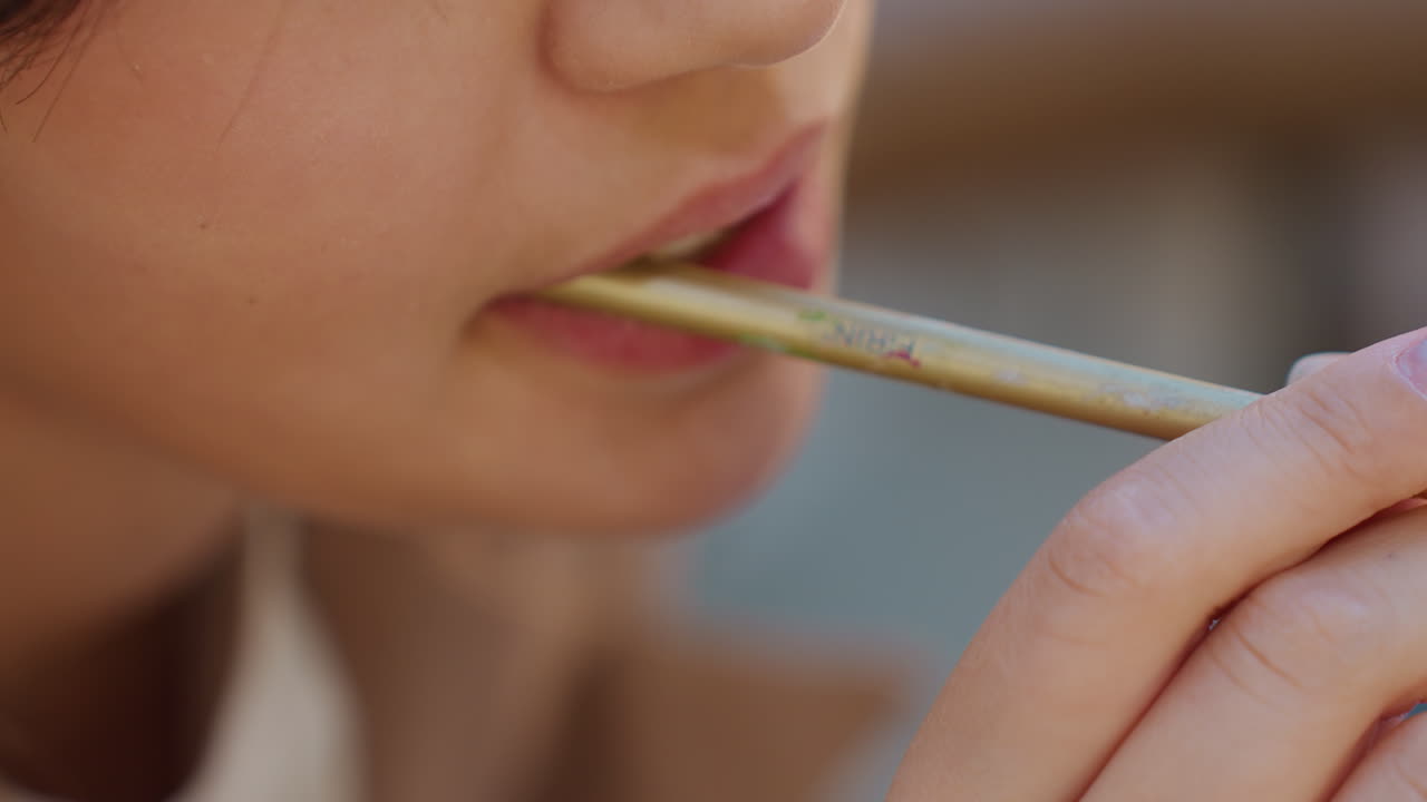 Aplicación de maquillaje de labios orientada al detalle, enfoque preciso en las técnicas de precisión con el pincel de labios, representación en primer plano del uso meticuloso del pincel de labios que enfatiza la elegancia y la precisión en las rutinas de belleza