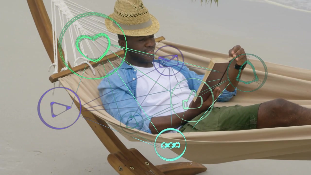 Man reclining in hammock on beach, tapping tablet to check social media icons shifting with hands