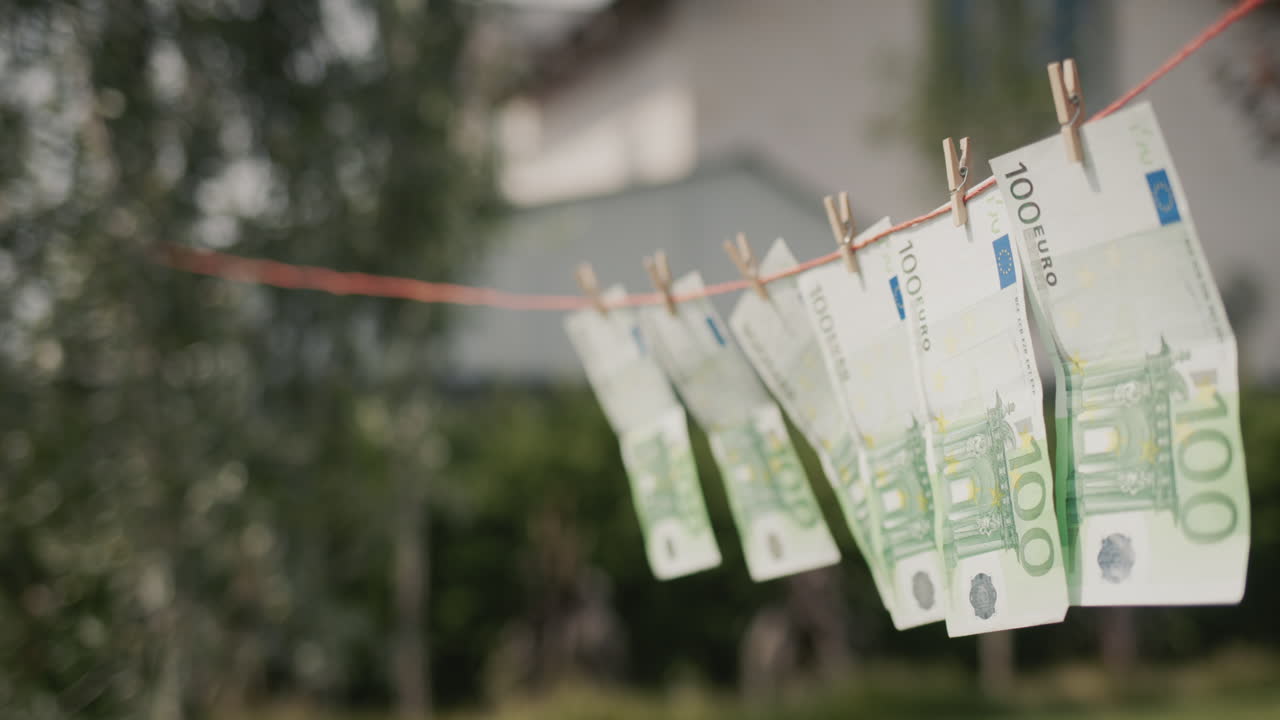 Kilka banknotów studolarowych suszy się na sznurze do bielizny. Koncepcja prania pieniędzy. Widok z boku.