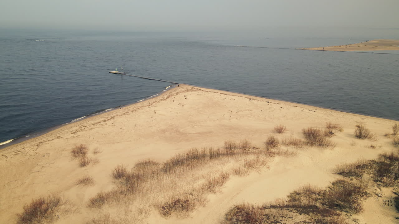 파도가 튀는 모래 해안선과 넓은 발트 해를 배경으로 보여주는 공중 조감도