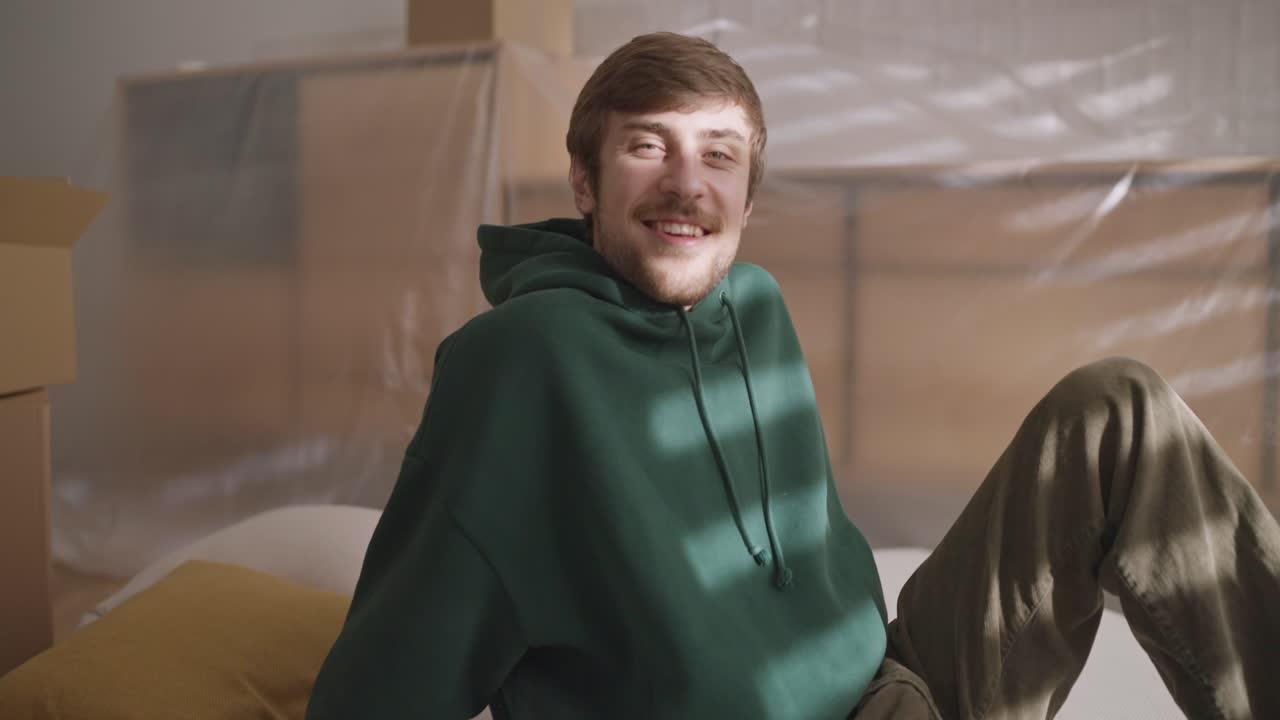 hombre sonriendo en un nuevo apartamento durante la mudanza