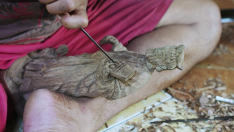 balinese craftsman making wood statue