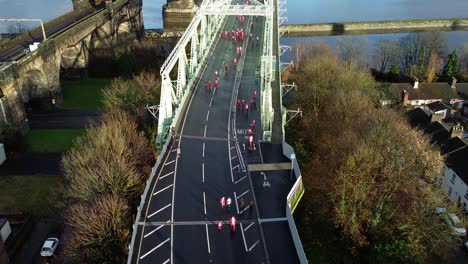 charity santa dash fun run over runcorn silver jubilee bridge aerial view rising tilt down shot