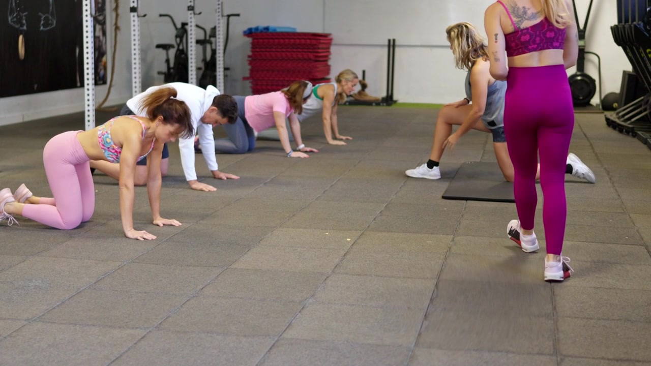 Group Fitness Class Performing Crawling Exercises in Gym