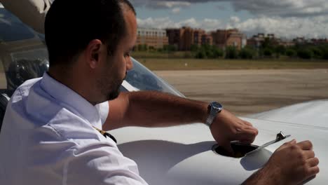 a pilot checking the engine oil level with the dipstick