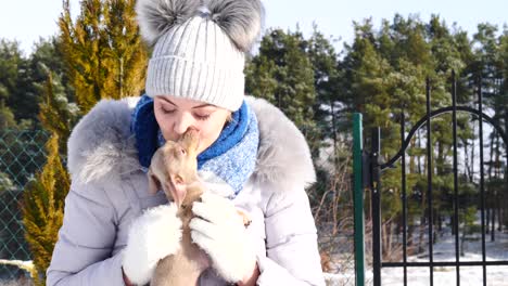 woman playing with her little dog outside winter