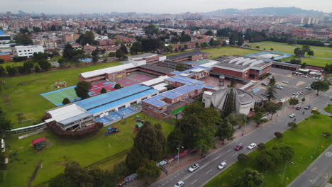 Aerial-Drone-Establishing-Shot-Circling-Around-Large-School-Building-Campus-Complex-During-The-Day-With-Daytime-Traffic