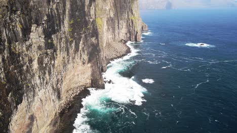 distant drone footage of cliffs and the witch finger at sandavagur on the vagar island in the faroe islands