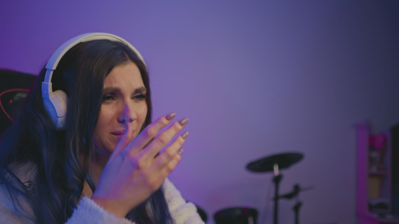 Side profile of unhappy music artist wearing white headphones expressing displeasure with record label, lips slightly pressed, soft blur background showing other recording and studio equipment