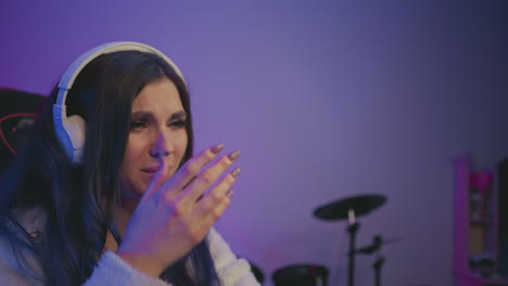 side profile of unhappy music artist wearing white headphones expressing displeasure with record label, lips slightly pressed, soft blur background showing other recording and studio equipment
