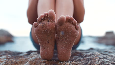 woman's feet on rocks at beach