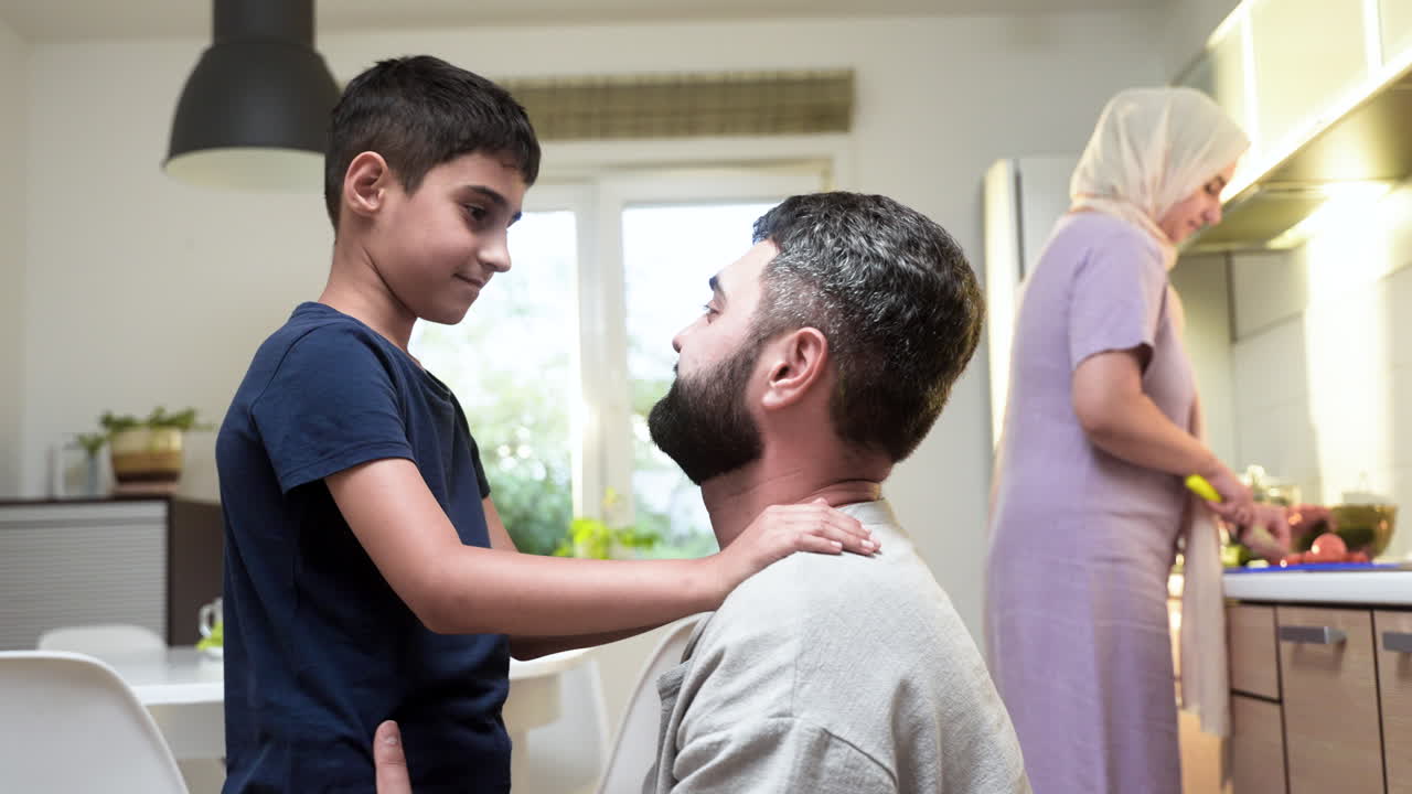 vista lateral de un niño y un hombre en la cocina.