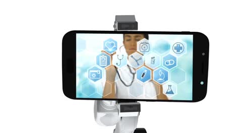 video generado digitalmente de un brazo robótico blanco sosteniendo un teléfono móvil que muestra iconos médicos en la pantalla
