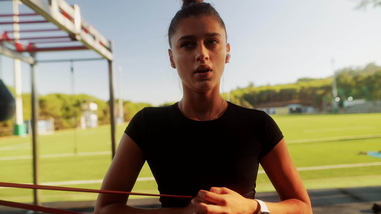Woman exercising with resistance band at outdoor gym